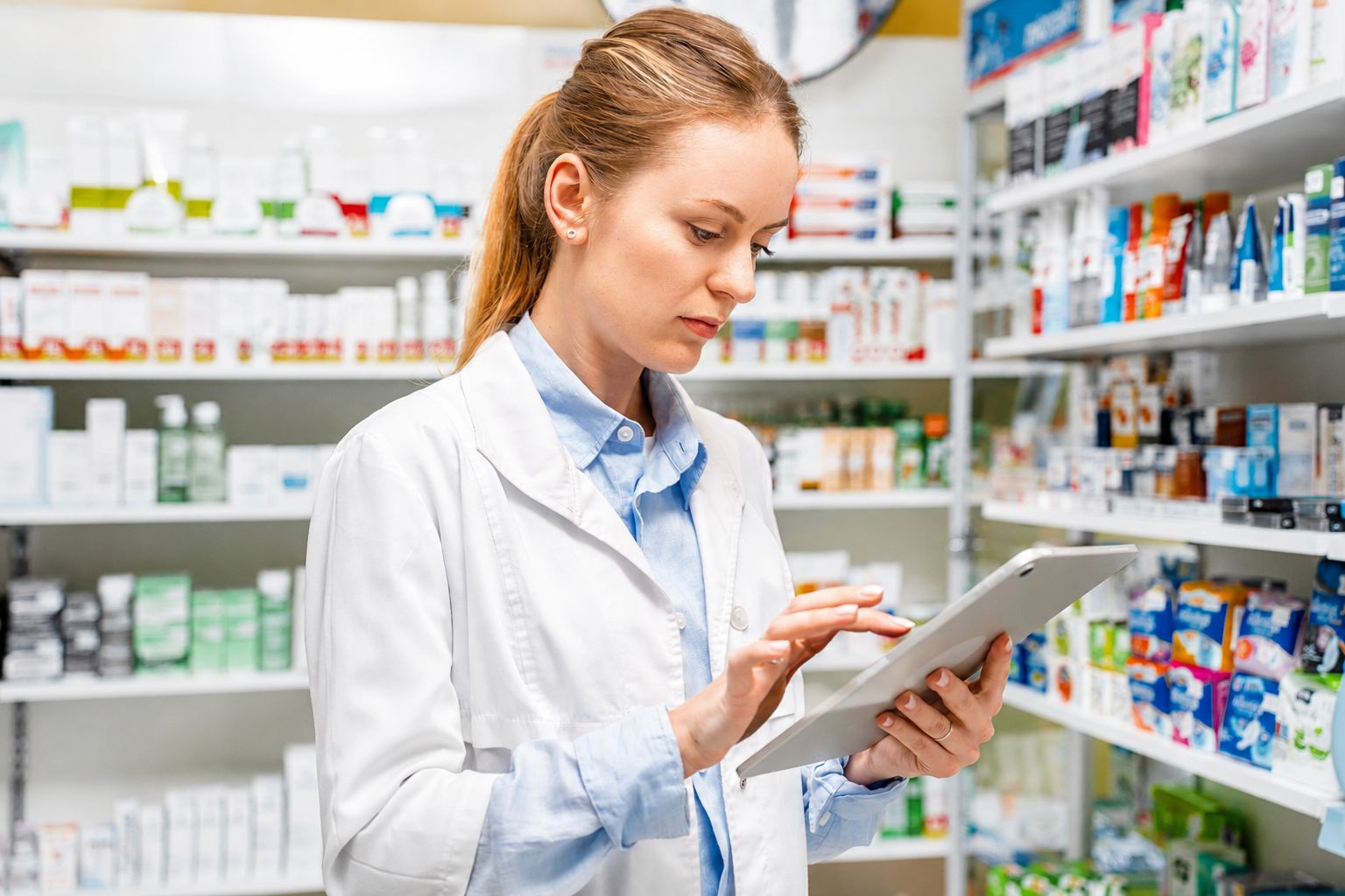 Farmacéutica revisando el proceso de compras de su institución de salud en una tablet con Portada Salud